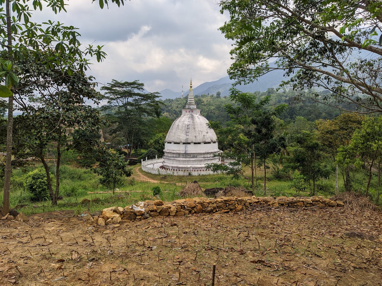 Historic Rathganga Stupa surrounded by lush greenery in Sri Lanka, showcasing Buddhist architecture.